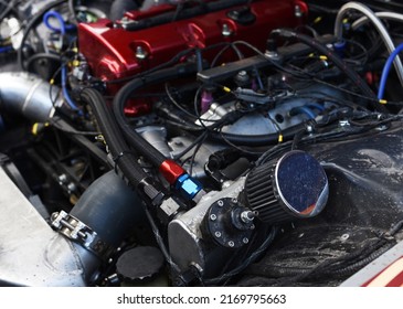 Sports Car Engine With Turbine. An Open Race Car Hood On A Pit Stop While Racing On A Race Track. Motor With Turbocharger. Boos And Tunning.