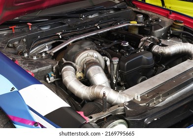 Sports Car Engine With Turbine. An Open Race Car Hood On A Pit Stop While Racing On A Race Track. Motor With Turbocharger. Boos And Tunning.