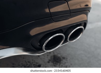 Sports car exhaust system pipes. Central exhaust pipes at the middle of bumper 