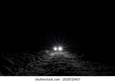 Sports Car With High Beam On In A Winter Pine Forest At Night, Front And Background Blurred With Bokeh Effect 