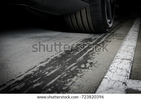 Sports car leaving wet tire prints on the asphalt