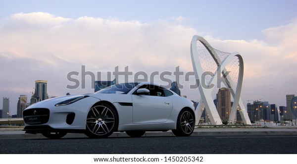 Sports car next to the monument with blue sky at\
Doha Qatar 13 April 2019