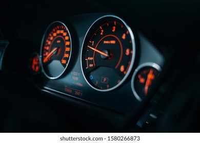 Sports car tachometer and dashboard with backlight. Modern car dashboard and cockpit with red illumination and arrows. Car engine is starting 