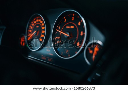 Sports car tachometer and dashboard with backlight. Modern car dashboard and cockpit with red illumination and arrows. Car engine is starting 