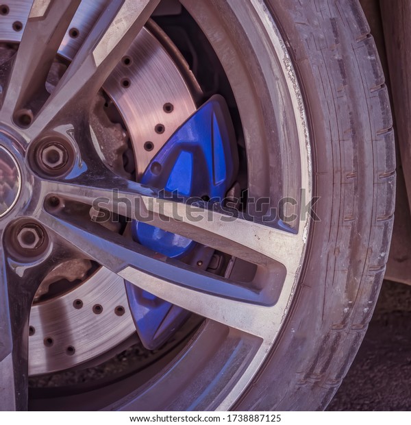 sports\
car wheel and disk brake with blue caliper\
closeup