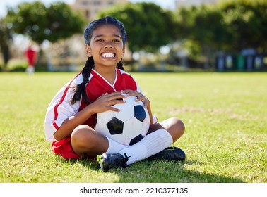 Sports, children and girl soccer player relax on grass with soccer ball, happy and excited at training. Fitness, smile and portrait of Indian child on field, ready for cardio, energy football workout - Powered by Shutterstock