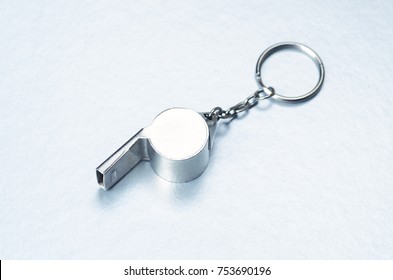 Sports Or Coaches Metal Whistle, Closeup. Concept Refereeing Sport On Silver Ice Background. Hockey Referee Whistle