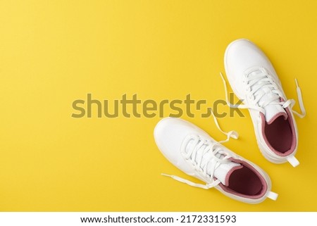 Sports concept. Top view photo of white stylish sneakers on isolated yellow background with copyspace 商業照片 © 