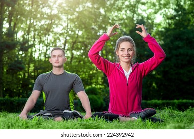 Sports Couple In Sportwear Having Yoga In The Park