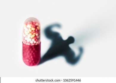 Sports doping, anabolic capsule - shape of a male muscular upper body - symbol for medical drug abuse.