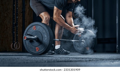 Sports equipment closeup concept. Cropped shot of male athlete preparing for workout with heavy weights clapping hands. - Powered by Shutterstock