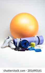 Sports Equipment, Gym Ball, Yoga Mat, Abs Roller, Sneakers, Apple, Skipping Rope, Measuring Tape And Water Bottle Closeup Isolated On White