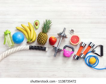 Sports Equipment And Healthy Food On A White Wooden Background. Top View. Motivation