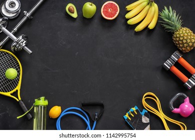 Sports Equipment And Organic Food On Black Background. Top View. Motivation