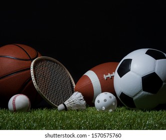 Sports equipment, rackets and balls on green grass with black background and copy space.
 - Powered by Shutterstock