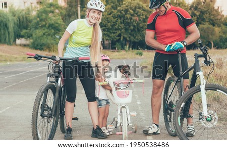 sports family holding bicycles in the city at the stadium