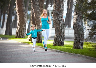 sports family mother and child daughter are engaged in running and athletics in the summer in the park