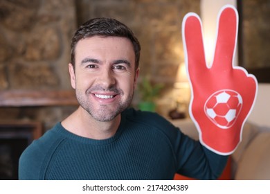 Sports fan holding large hand foam with joy  - Powered by Shutterstock