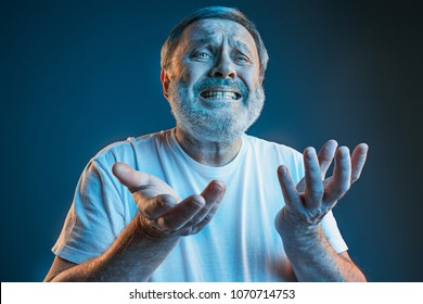 Sports, Fan Human Emotions And People Concept - Sad Senior Man Watching Sports On Tv And Supporting Team At Home. Crying Emotional Man Screaming In Colorful Bright Lights At Studio. Facial Expression