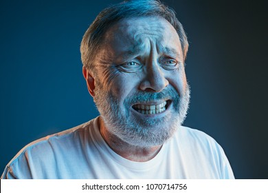 Sports, Fan Human Emotions And People Concept - Sad Senior Man Watching Sports On Tv And Supporting Team At Home. Crying Emotional Man Screaming In Colorful Bright Lights At Studio. Facial Expression