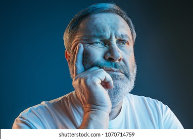 Sports, Fan Human Emotions And People Concept - Sad Senior Man Watching Sports On Tv And Supporting Team At Home. Crying Emotional Man Screaming In Colorful Bright Lights At Studio. Facial Expression