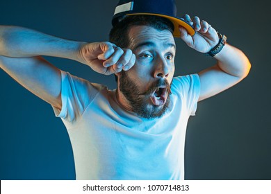 Sports, Fan Human Emotions And People Concept - Sad Young Man Watching Sports On Tv And Supporting Team At Home. Crying Emotional Man Screaming In Colorful Bright Lights At Studio. Facial Expression