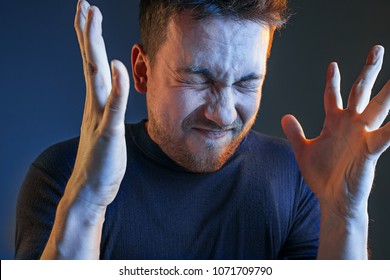 Sports, Fan Human Emotions And People Concept - Sad Young Man Watching Sports On Tv And Supporting Team At Home. Crying Emotional Man Screaming In Colorful Bright Lights At Studio. Facial Expression