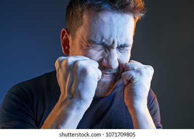 Sports, Fan Human Emotions And People Concept - Sad Young Man Watching Sports On Tv And Supporting Team At Home. Crying Emotional Man Screaming In Colorful Bright Lights At Studio. Facial Expression