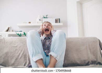 Sports, Fan Human Emotions And People Concept - Sad Young Man Watching Sports On Tv And Supporting Team At Home. Crying Emotional Man Screaming In Colorful Bright Lights At Studio. Facial Expression
