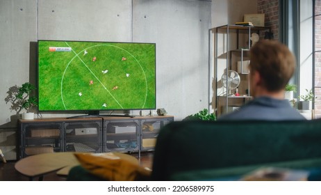 Sports Fan Watches Important Soccer Match on TV at Home, He Is Focused on Intense Championship Finals, Cheering for His Team. His Successful Team Scores and Leading the Game. - Powered by Shutterstock