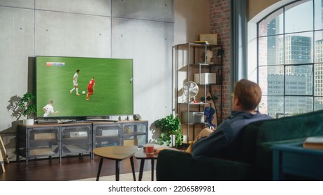 Sports Fan Watches Important Soccer Match on TV at Home, He Is Focused on Intense Championship, Cheering for His Team. His Successful Team Scores and Leading the Game. - Powered by Shutterstock