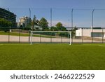 Sports field in a residential area with artificial green grass and football goal at Santo Tirso Municipal Sports Complex in Portugal.