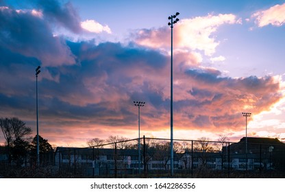 Sports Field In A Residential Community With Very Tall Floodlights At Dusk