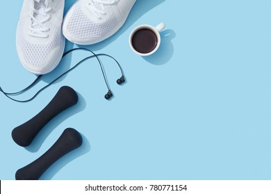 Sports Flat Lay With Coffee, Dumbbells, Sneakers And Earphones On Blue Background