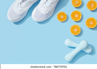 Sports Flat Lay With Oranges, Dumbbells And Sneakers On Blue Background