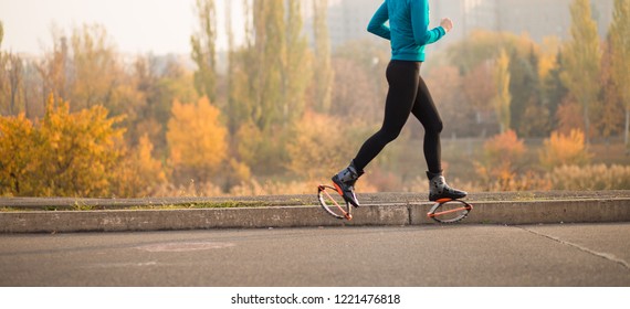 Sports girl in shoes for kangoo jumping run by autumn street - Shutterstock ID 1221476818