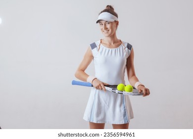 sports girl tennis player in a light uniform with a tennis racket on a clean background, the concept of tennis - Powered by Shutterstock