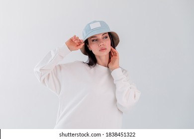 Sports girl in white loCopy spacego sweatshirt. Woman in denim hat. beautiful brunette.