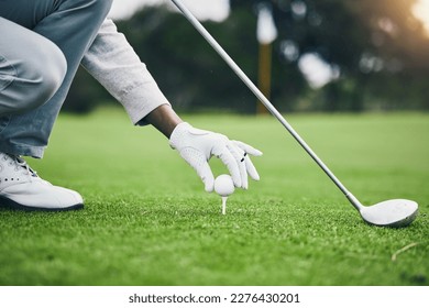 Sports, golf ball and tee with hand of black man on field for training, tournament and challenge. Start, competition match and ready with athlete and club on course for action, games and hobby - Powered by Shutterstock