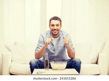 Sports, Happiness And People Concept - Smiling Man Watching Sports On Tv And Supporting Team At Home