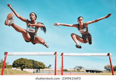 Sports, hurdles and team of women on track running in a race, marathon or competition in stadium. Fitness, workout and female athletes jumping with speed and energy for outdoor training or practice. - Powered by Shutterstock