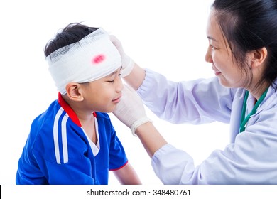 Sports Injury. Athlete Little Asian (thai) Boy In Blue Sportswear With Trauma Of The Head, Bloody On Bandage. Doctor Makes A Bandage On Head Patient, On White Background. Studio Shoot. Side View.