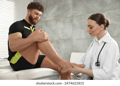 Sports injury. Doctor examining patient's foot in hospital - Powered by Shutterstock