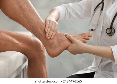 Sports injury. Doctor examining patient's foot in hospital, closeup - Powered by Shutterstock