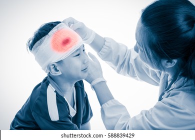 Sports Injury. Sad Asian Boy With Trauma Of Head Crying, Bloody On Bandage. Doctor Makes Bandage On Head Patient, On White Background. Color Increase Blue Skin And Red Spot Indicating Location Of Pain