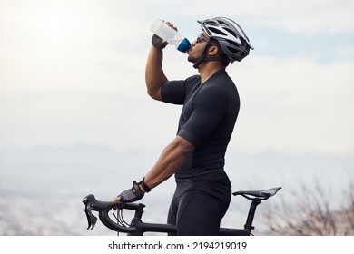 Sports man with a bike drinking water bottle doing fitness training or workout on sky mockup background. Healthy, professional athlete cyclist with a bicycle during cycling cardio exercise in nature