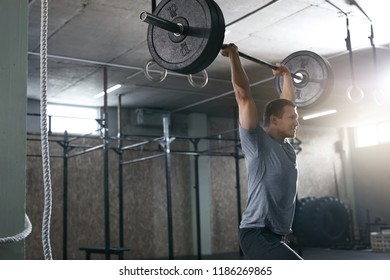 Sports Man Lifting Barbell Row At Workout Gym