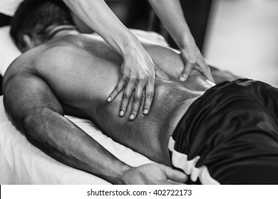 Sports Massage - Lower Back Massage - Physical Therapist Doing Massage Of Lower Back. Black And White Photo, Selective Focus.