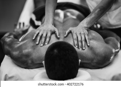Sports massage - Shoulder massage - Physical therapist doing massage of shoulders. Black and white photo, selective focus.