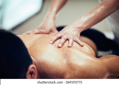 Sports Massage. Massage Therapist Massaging Lower Back Of A Male Athlete. Toned Image